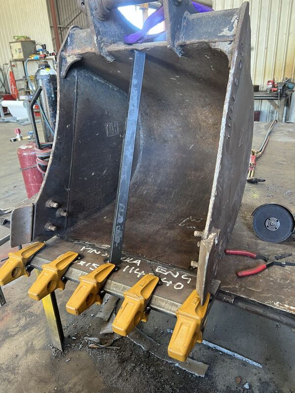 Excavator bucket clamped up in the workshop for repair